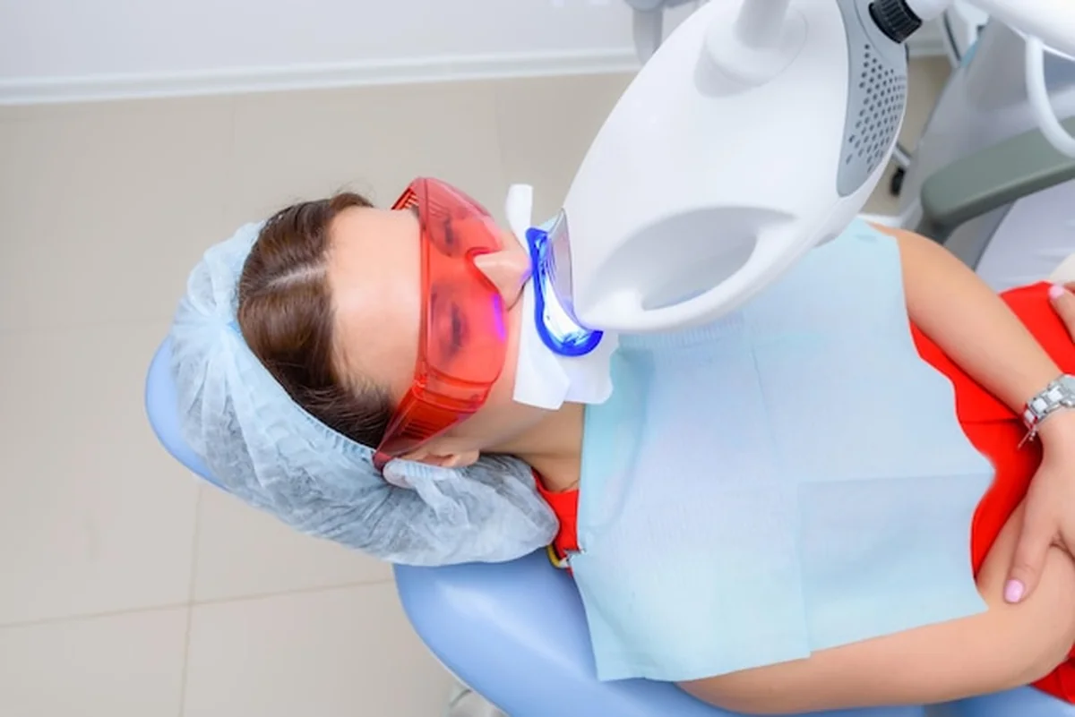 Pacjent przechodzi wybielanie zębów lampą ultrafioletową