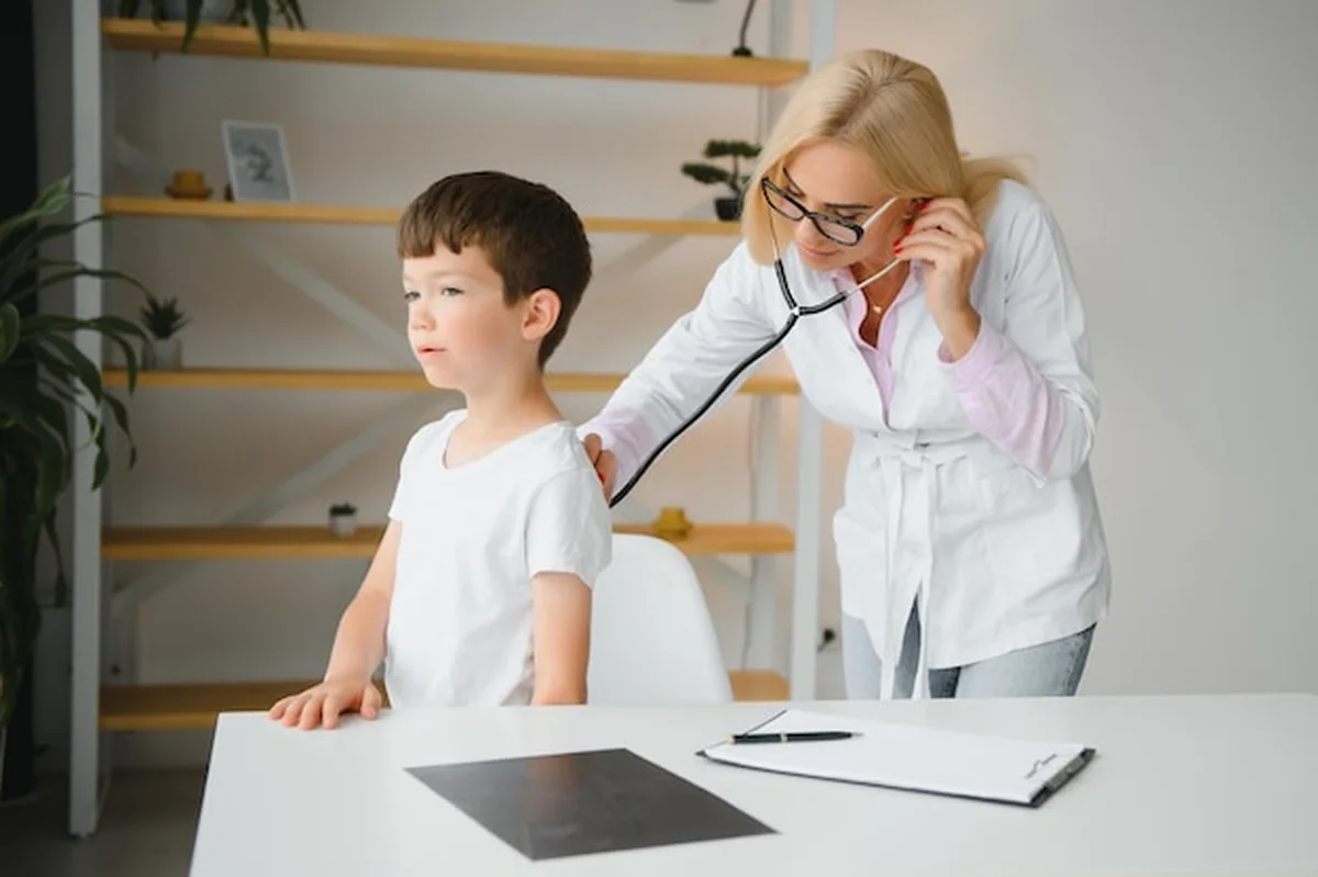 Kobieta lekarz bada chłopca stetoskopem