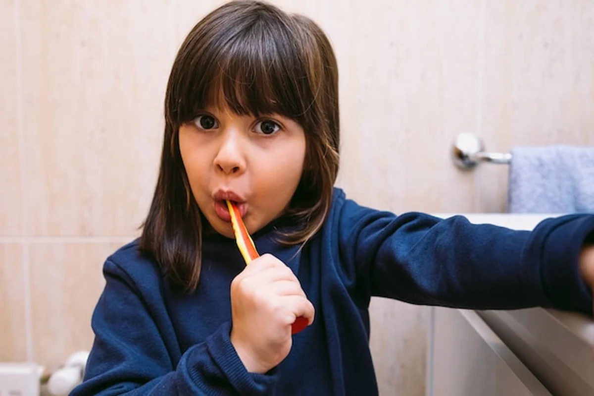 Dziewczynka myjąca zęby w łazience. Koncepcja higieny i dzieciństwa