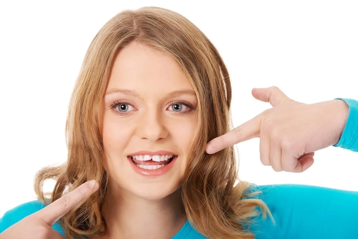 Młoda kobieta pokazująca zęby na białym tle